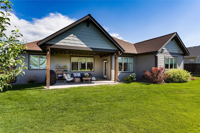 back of property with outdoor lounge area, a patio, and a lawn