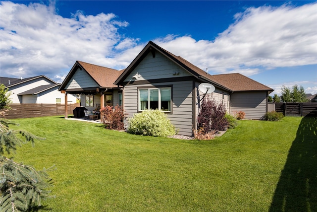 rear view of house with a patio and a yard