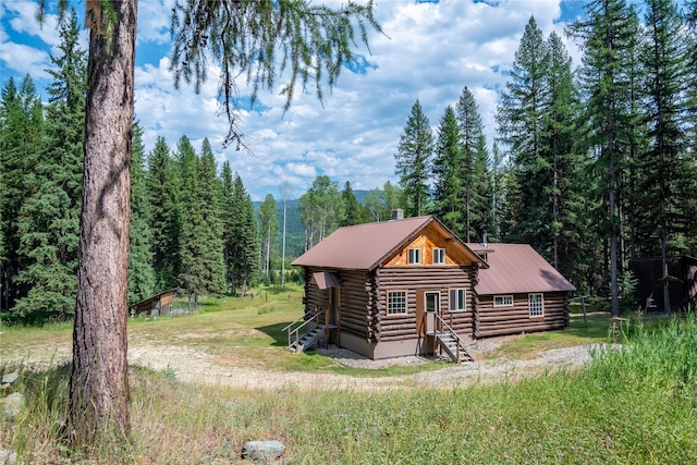 log home featuring a view of trees and log exterior