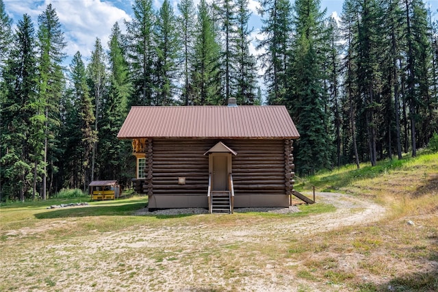 view of outbuilding featuring a wooded view and an outbuilding