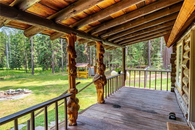 back of property with log exterior, a chimney, metal roof, a yard, and a wooded view