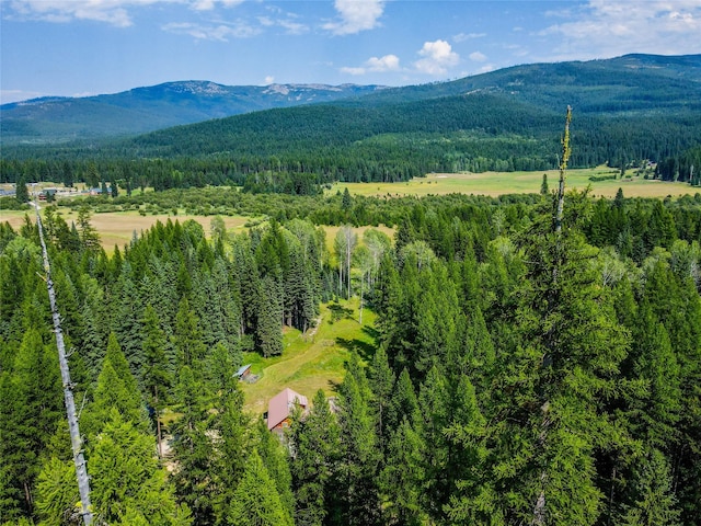 view of property exterior with metal roof, a chimney, log siding, and a view of trees