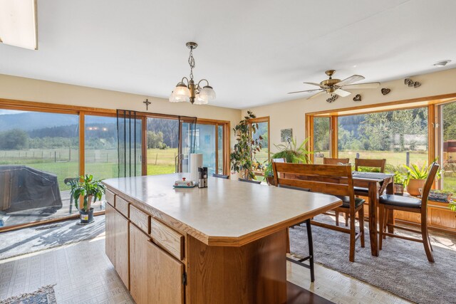 kitchen featuring ceiling fan with notable chandelier, a mountain view, a center island, and pendant lighting