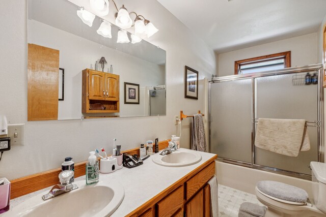 full bathroom featuring tile patterned flooring, toilet, dual vanity, and enclosed tub / shower combo