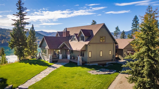 view of front of house featuring a mountain view, covered porch, and a front lawn