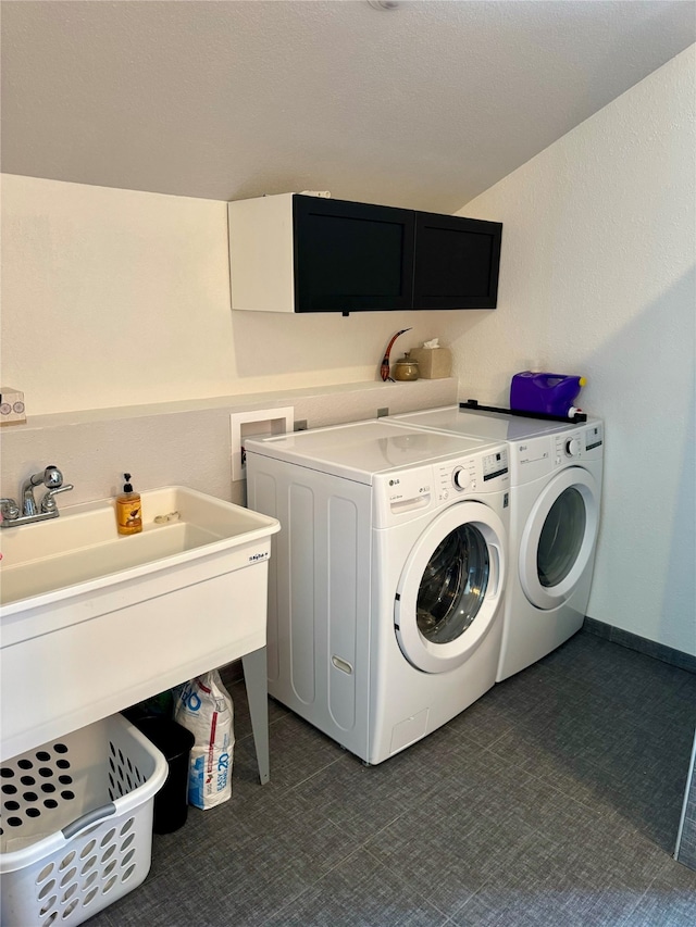 laundry area with separate washer and dryer and cabinets