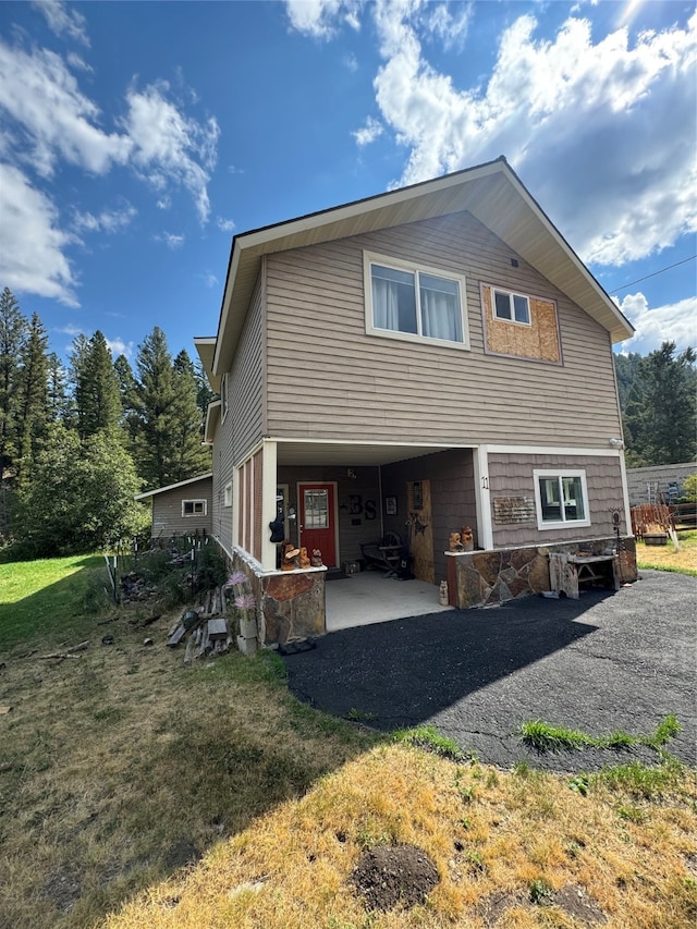 rear view of house with a lawn and a patio