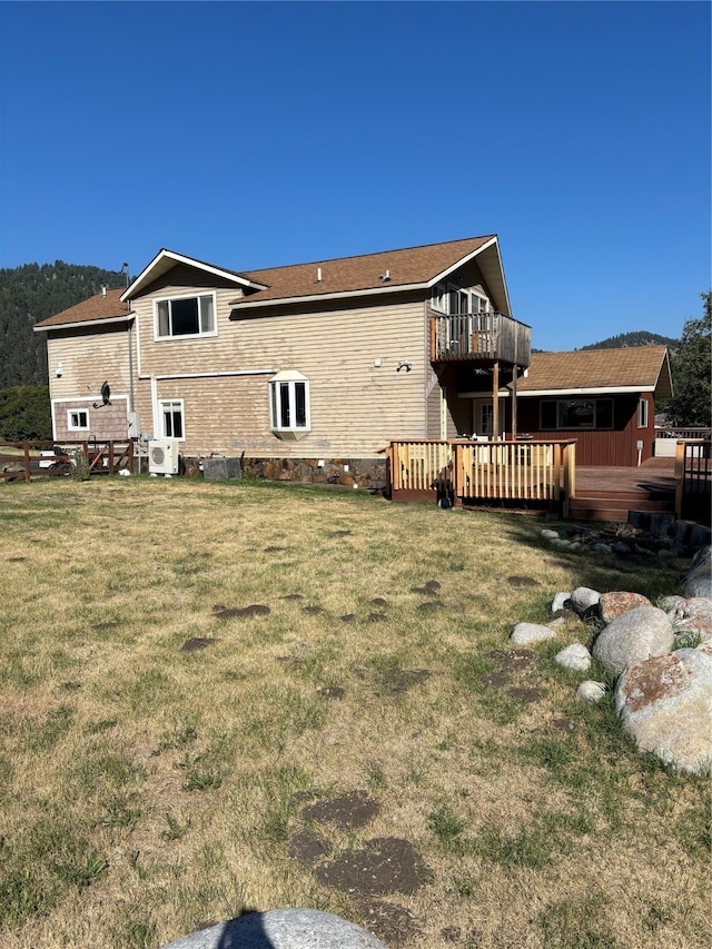 back of house featuring ac unit, a wooden deck, and a lawn