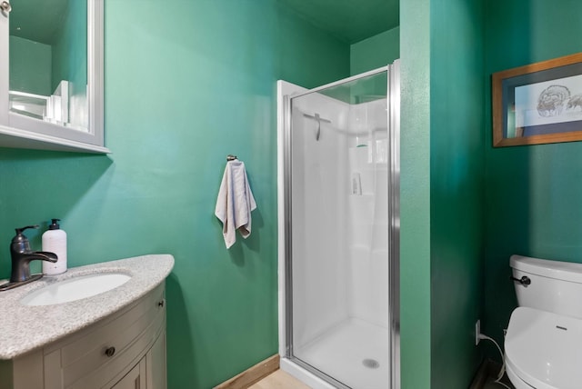 full bathroom with a stall shower, vanity, and toilet