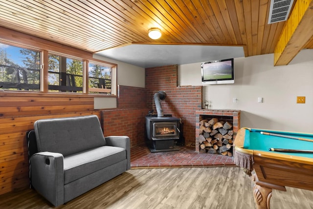 living area featuring wooden ceiling, visible vents, light wood-style flooring, and a wood stove