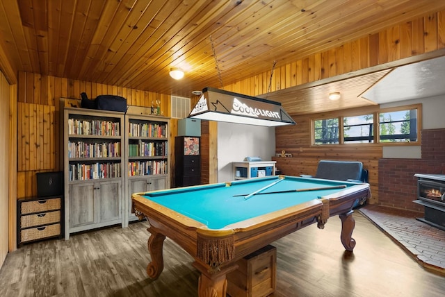 recreation room featuring wood ceiling, wood finished floors, a wood stove, and wooden walls