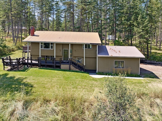 bi-level home featuring a front yard, stairs, metal roof, and a wooden deck