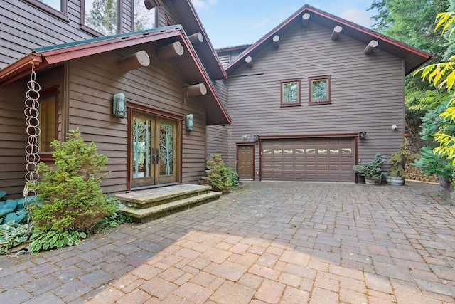 exterior space with decorative driveway, french doors, and a garage