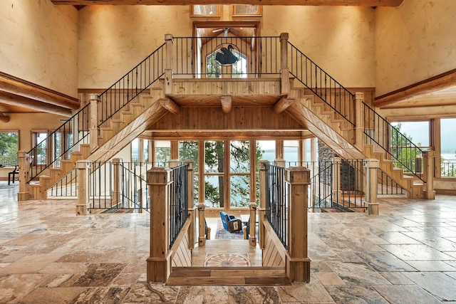 stairway with stone tile flooring and a high ceiling