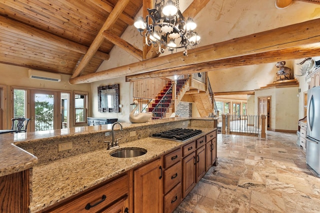 kitchen with beamed ceiling, a wall mounted AC, a sink, stainless steel appliances, and wood ceiling