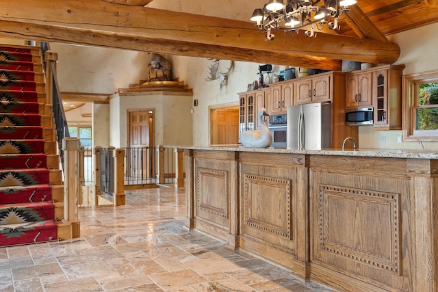 kitchen featuring an inviting chandelier, lofted ceiling with beams, glass insert cabinets, and appliances with stainless steel finishes