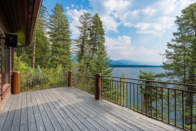 wooden terrace featuring a water and mountain view