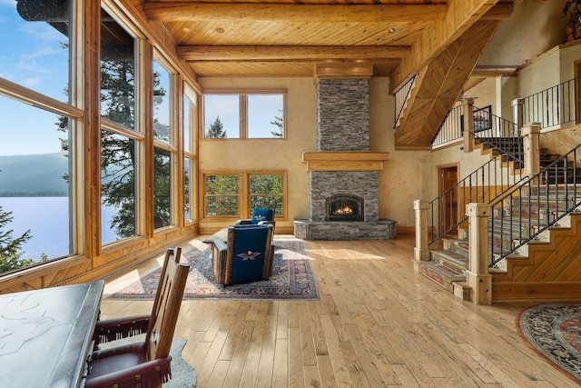 living area with a wealth of natural light, beam ceiling, wooden ceiling, and hardwood / wood-style flooring