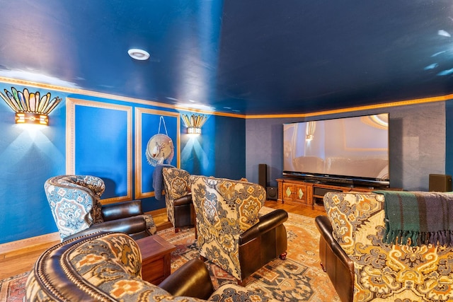 cinema featuring crown molding, wood finished floors, and baseboards