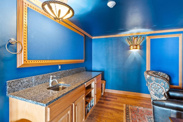 interior space featuring hardwood / wood-style floors, baseboards, and a sink