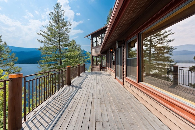 wooden terrace featuring a water and mountain view