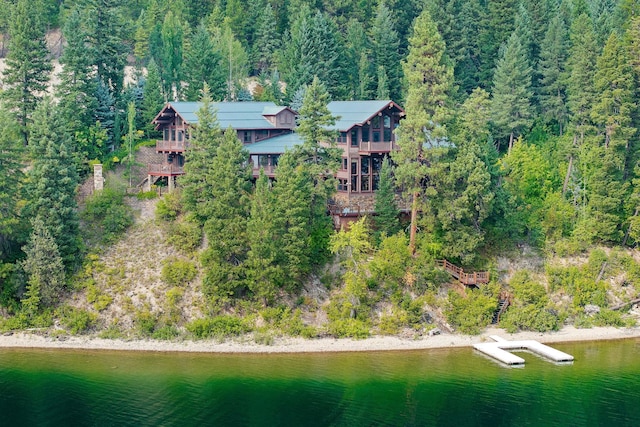 birds eye view of property with a view of trees and a water view