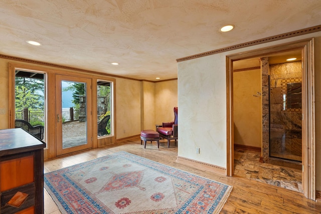 living area featuring crown molding, hardwood / wood-style flooring, recessed lighting, and baseboards