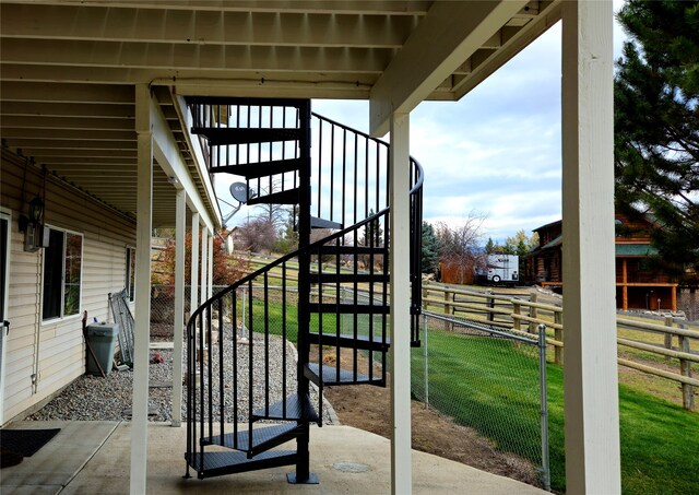 view of patio with stairs and fence