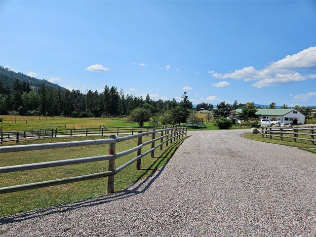 view of road featuring a rural view and gravel driveway