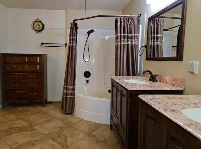 full bath featuring tile patterned flooring, vanity, shower / bath combo with shower curtain, and a textured ceiling