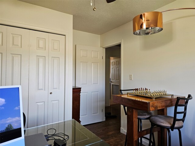 dining room featuring dark wood finished floors and a textured ceiling