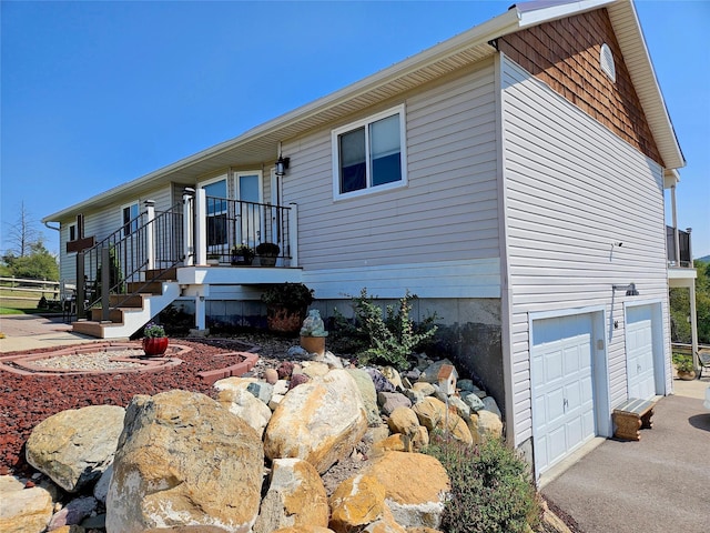 view of side of home featuring aphalt driveway and an attached garage