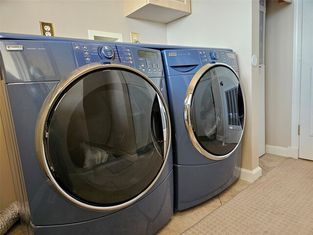 laundry room with washer and clothes dryer, laundry area, baseboards, and light tile patterned flooring