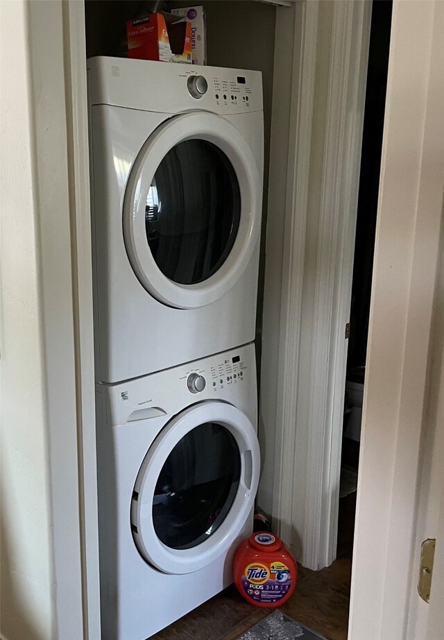 washroom with stacked washer and dryer and laundry area