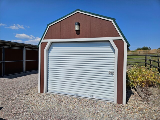 garage featuring a storage unit and fence