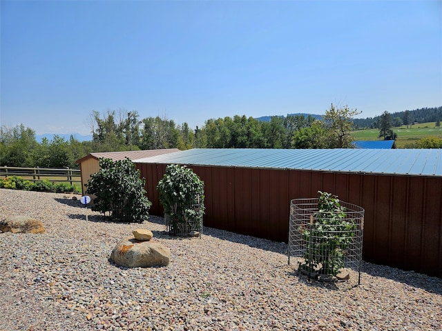 view of yard featuring an outbuilding, fence, and a pole building