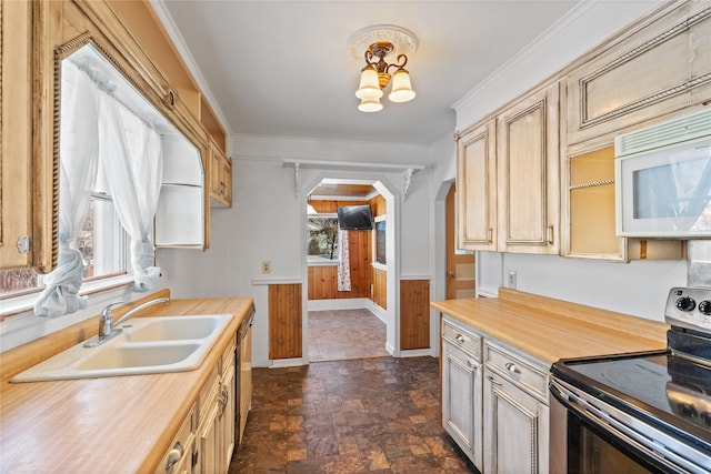 kitchen with appliances with stainless steel finishes, crown molding, sink, light brown cabinets, and a notable chandelier