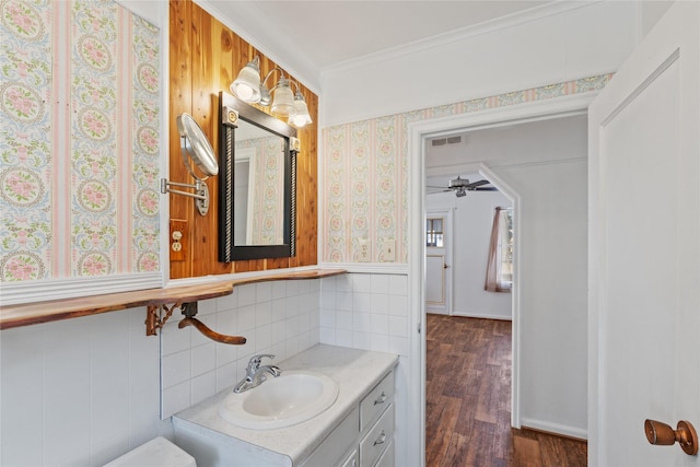 bathroom with hardwood / wood-style floors, ceiling fan, crown molding, and vanity