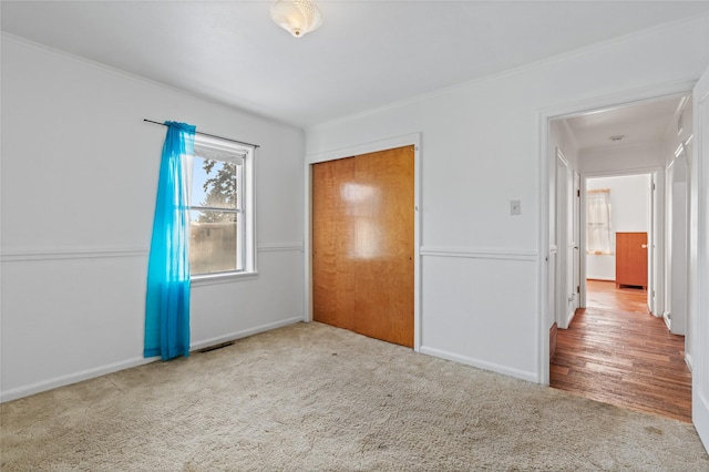 unfurnished bedroom featuring light carpet and a closet