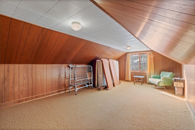 bonus room featuring carpet flooring, wood walls, and lofted ceiling