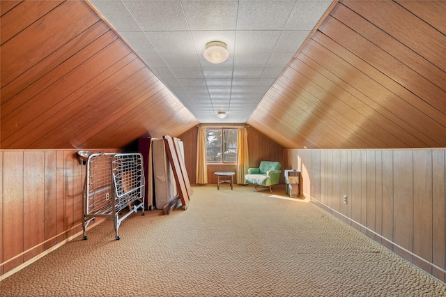 additional living space featuring carpet floors, wooden walls, and vaulted ceiling