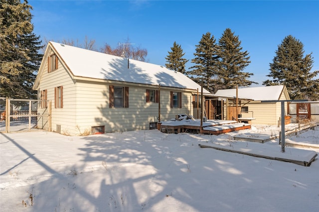 snow covered rear of property featuring a deck