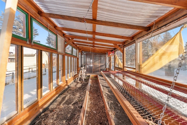 unfurnished sunroom featuring lofted ceiling with beams