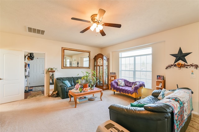 carpeted living room featuring a textured ceiling and ceiling fan