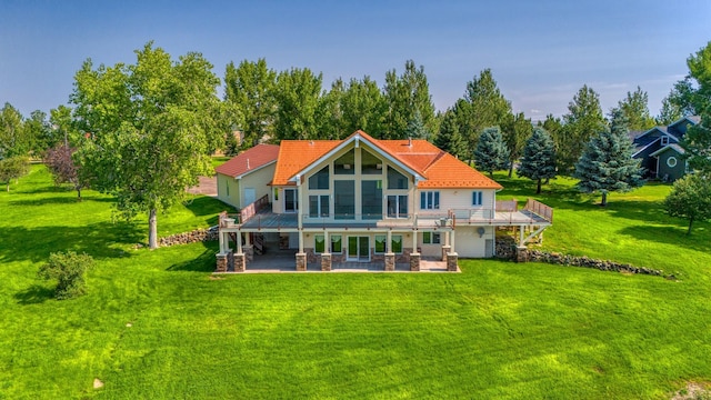 back of property with a yard, a deck, and a patio area