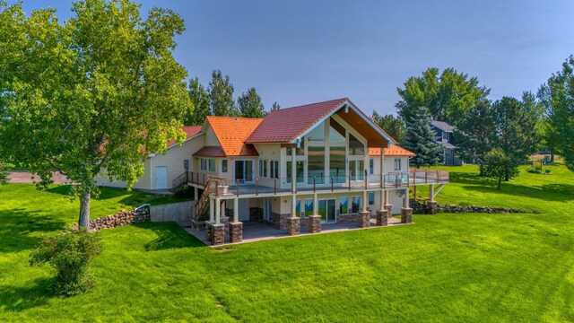 rear view of house with a patio area, a yard, and a deck