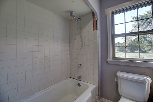 bathroom with tiled shower / bath and toilet