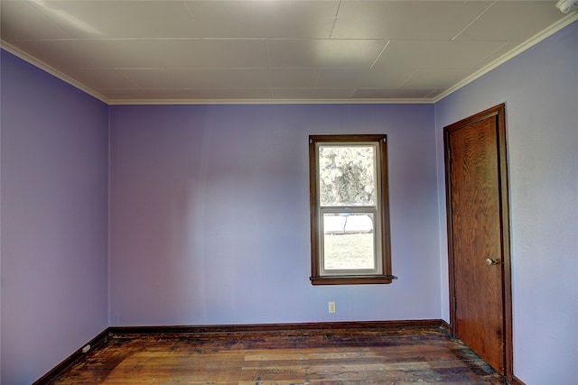 empty room featuring dark wood-type flooring and ornamental molding