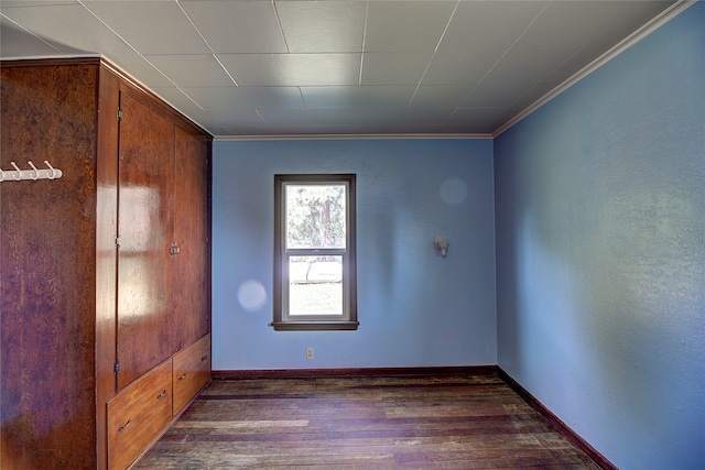 empty room with ornamental molding and dark hardwood / wood-style floors