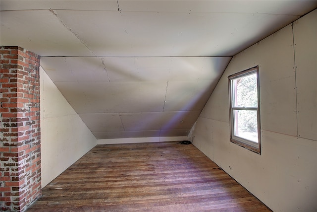 bonus room with hardwood / wood-style flooring and vaulted ceiling